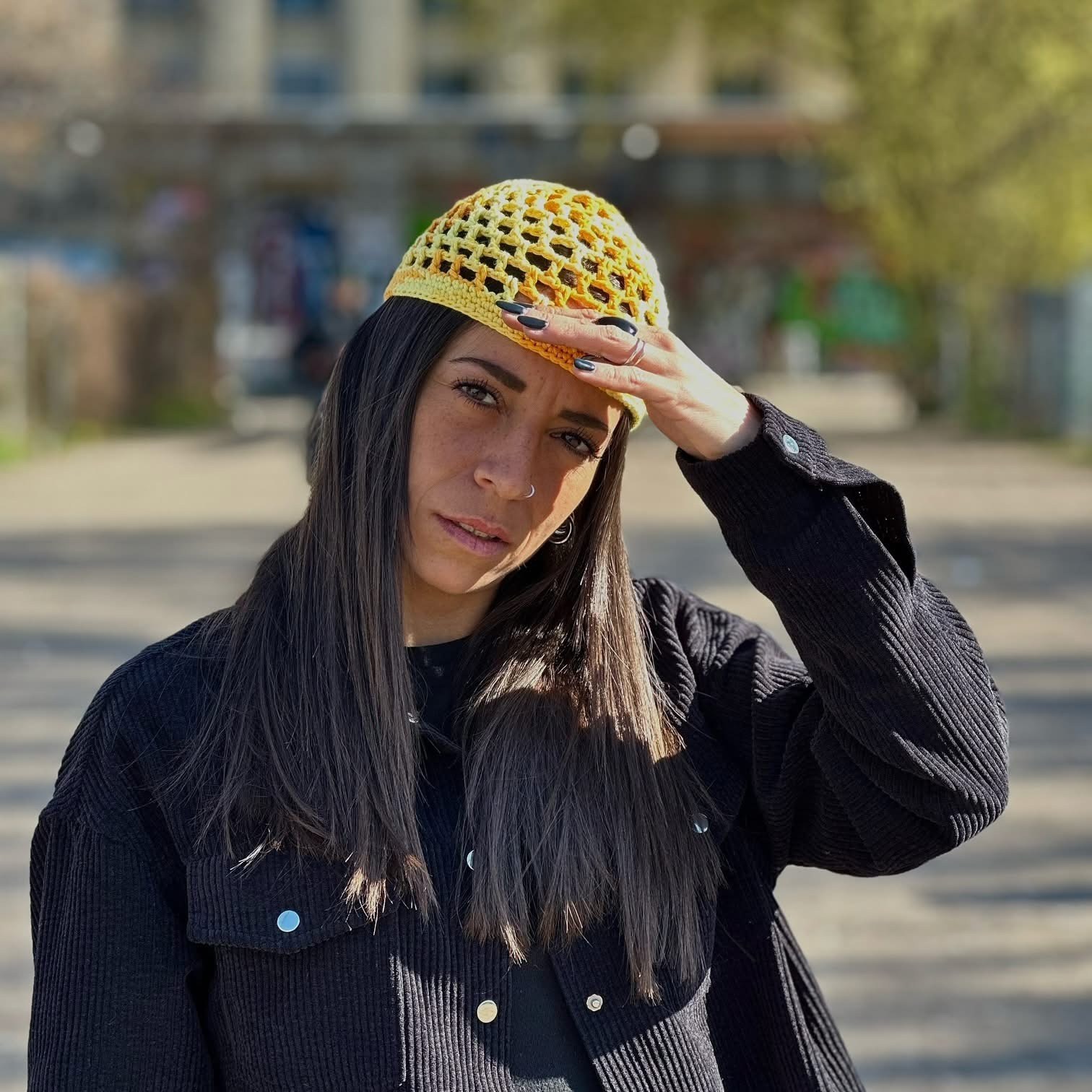 Cappello giallo crochet con un outfit nero