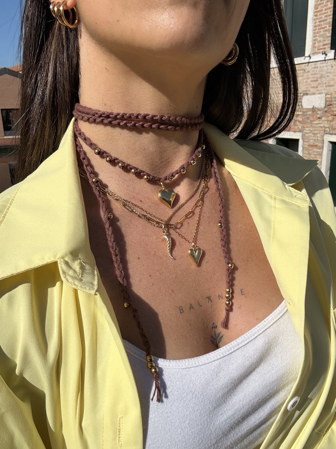 Collana crochet rosa antico con charms dorati, indossata