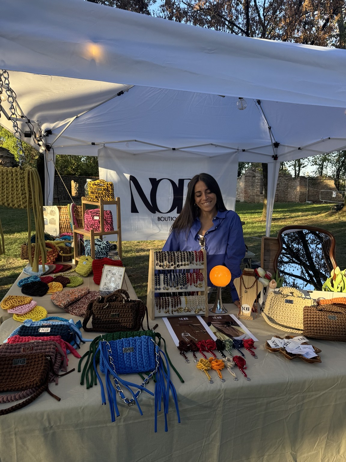 Stefania al banco di Node Boutique durante un mercatino, con le sue creazioni all’uncinetto
